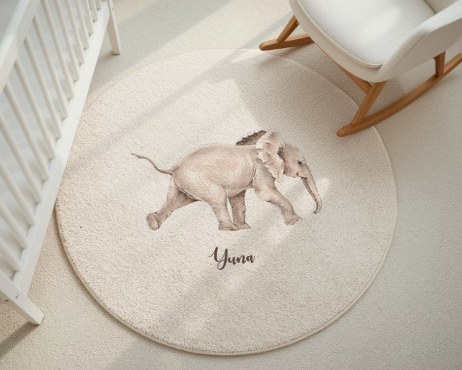 Round rug with an elephant design and 'Yuna' text in a nursery setting.