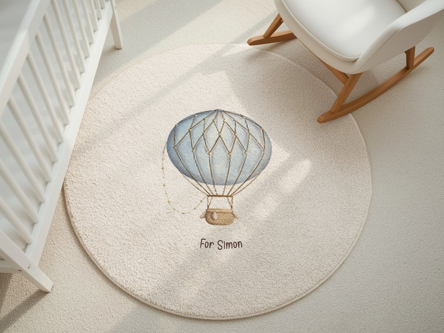 Round rug with a hot air balloon design in a room with a crib and rocking chair.