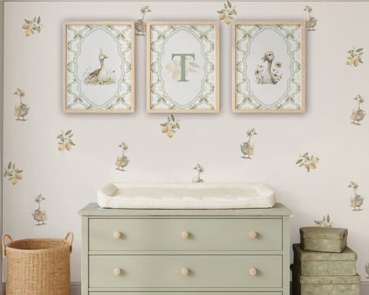 Nursery room with a green dresser, framed artwork, and decorative elements.