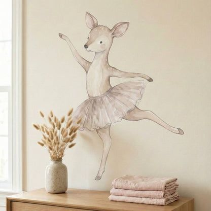 Ballerina deer wall sticker applied above a wooden dresser in a neutral nursery, showing a soft watercolor look with a painted-on finish.
