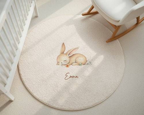 Round beige rug with a bunny design and 'Emma' text in a nursery setting.