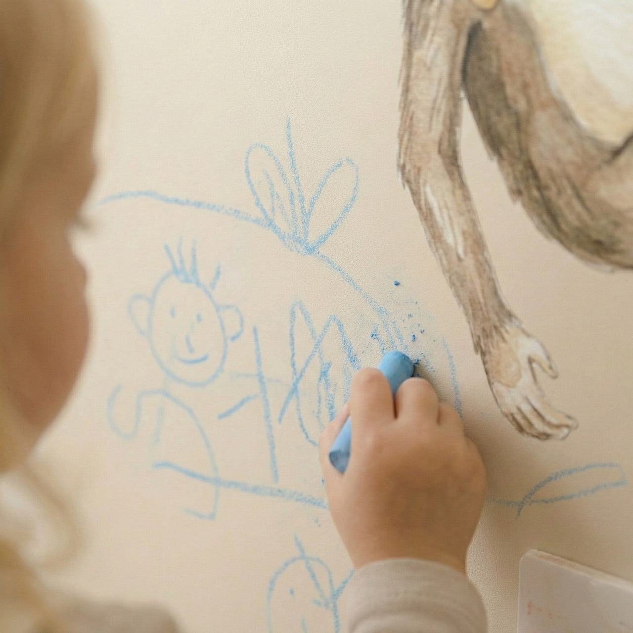 Child drawing with chalk on magnetic wall sticker in nursery room, creative toddler wall decor