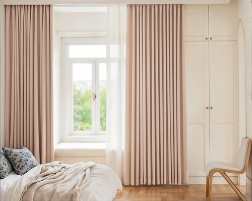 Beige curtains in a bedroom with a bed and chair.