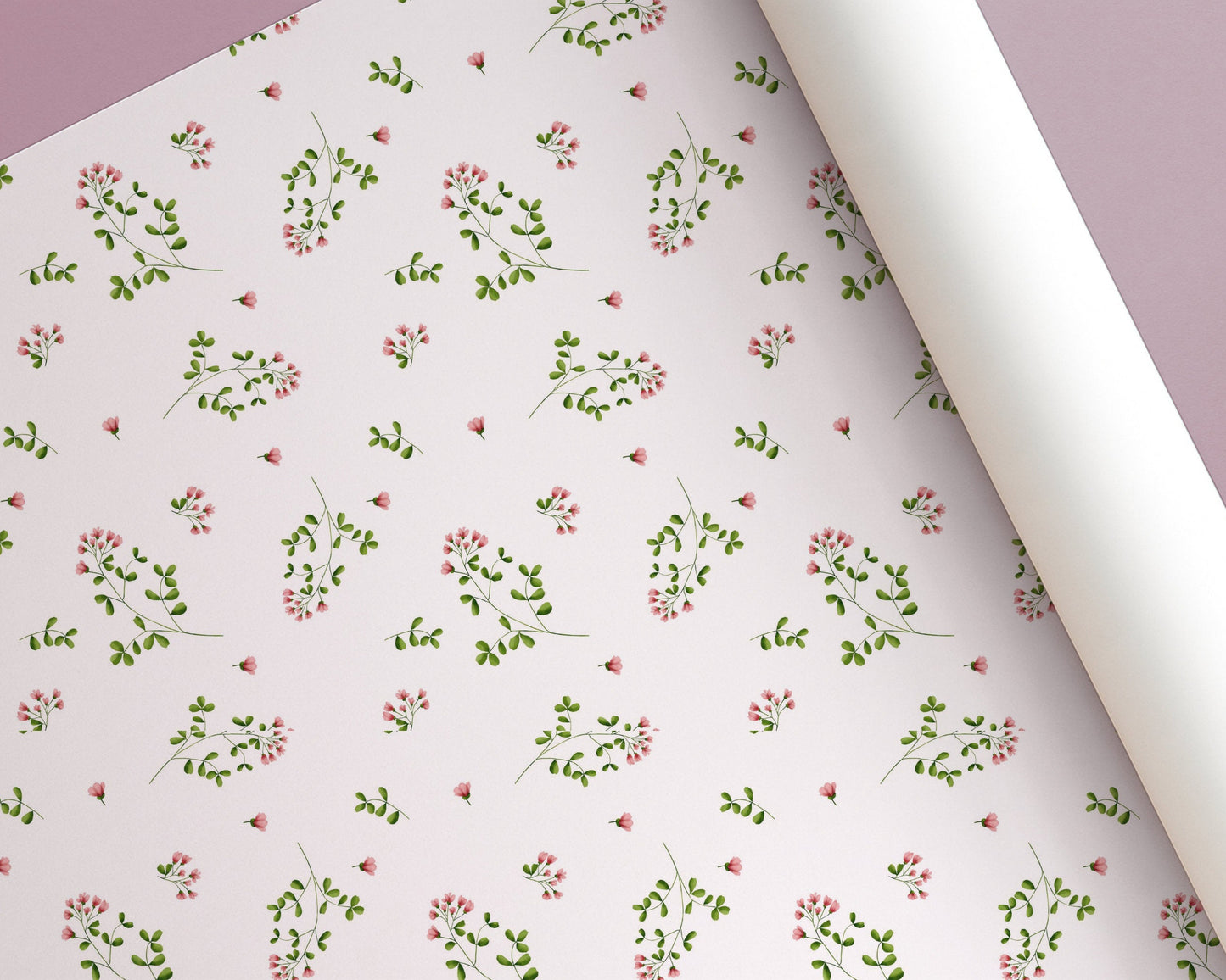 Roll of floral-patterned paper with small pink flowers and green leaves on a light background.