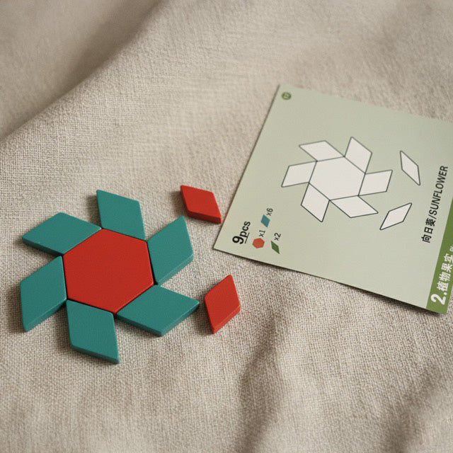 A sunflower pattern card being used with red and teal magnetic wooden shapes for STEM learning.