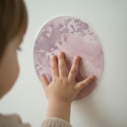 Close-up of a child touching a matte watercolor planet wall sticker, showing the soft texture and realistic finish.